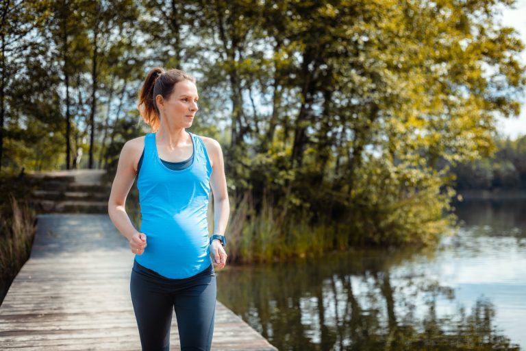 Active pregnant woman running outdoor, sport during pregnancy