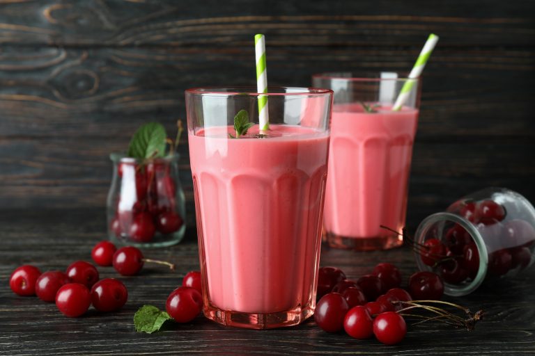 Cherry smoothie and ingredients on rustic wooden table