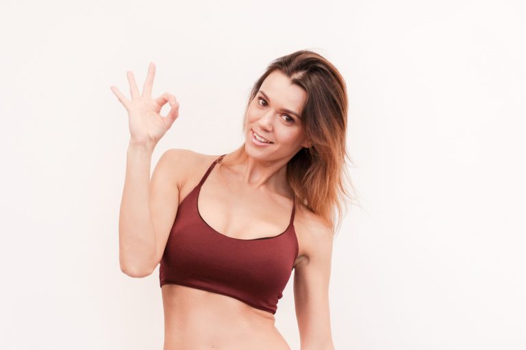 Cute athletic slim smiling girl at the top shows up OK on white background