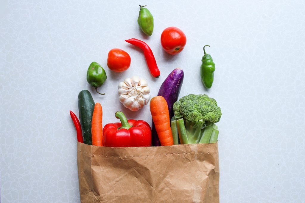 Healthy vegan vegetarian food spread out from paper bag vegetables