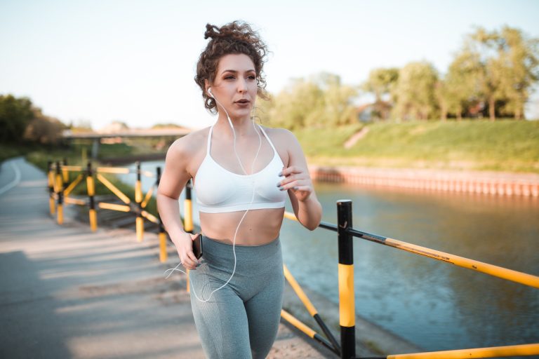 Woman running near a river during cardio exercise