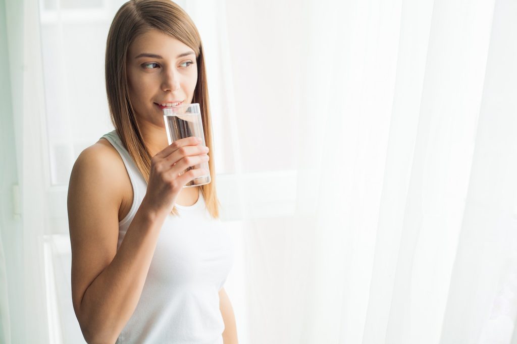 Young woman drinking water. Drinking fresh water